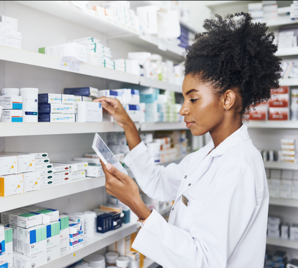 Hospital pharmacist checking stock on a dispensary shelf