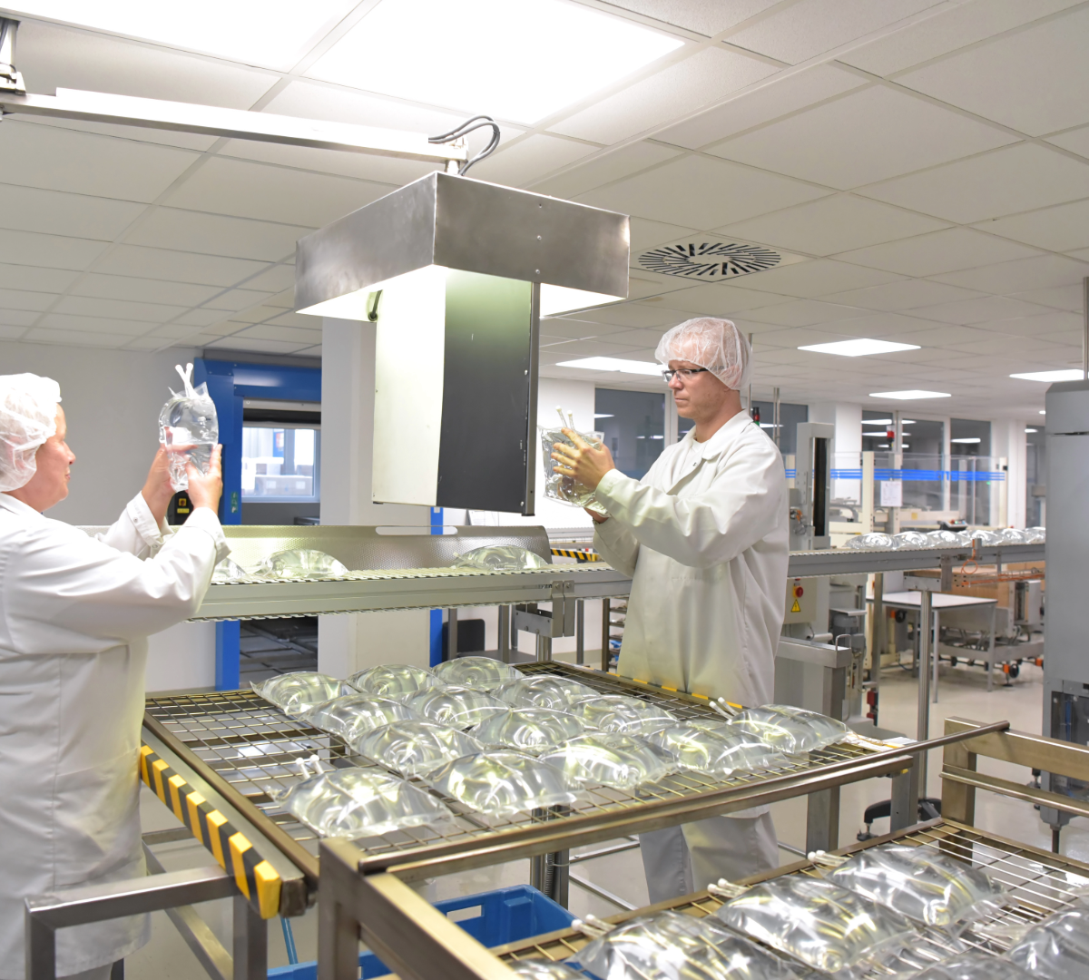 Technicians in sterile gowns working in a compounding pharmacy facility, where 503A and 503B preparation takes place